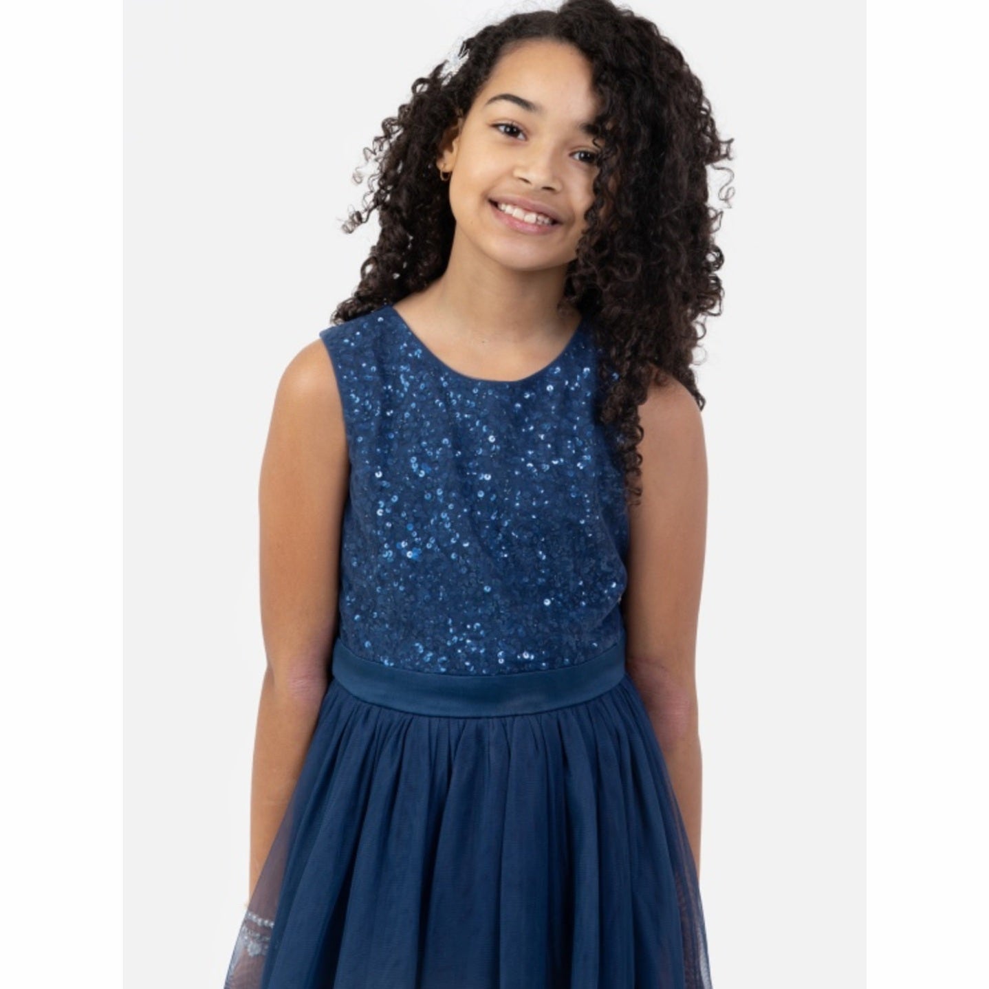 Young girl wearing a blue sequin dress on a white background