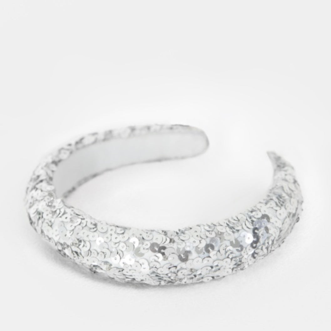 Silver ring with a textured band on a white background